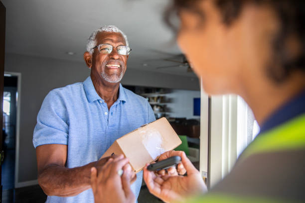 a young black woman delivers a package to a senior black man